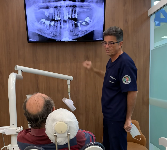 Dr. Hugo Robertson analisando exame de imagem para planejamento de implante em paciente com perda óssea.